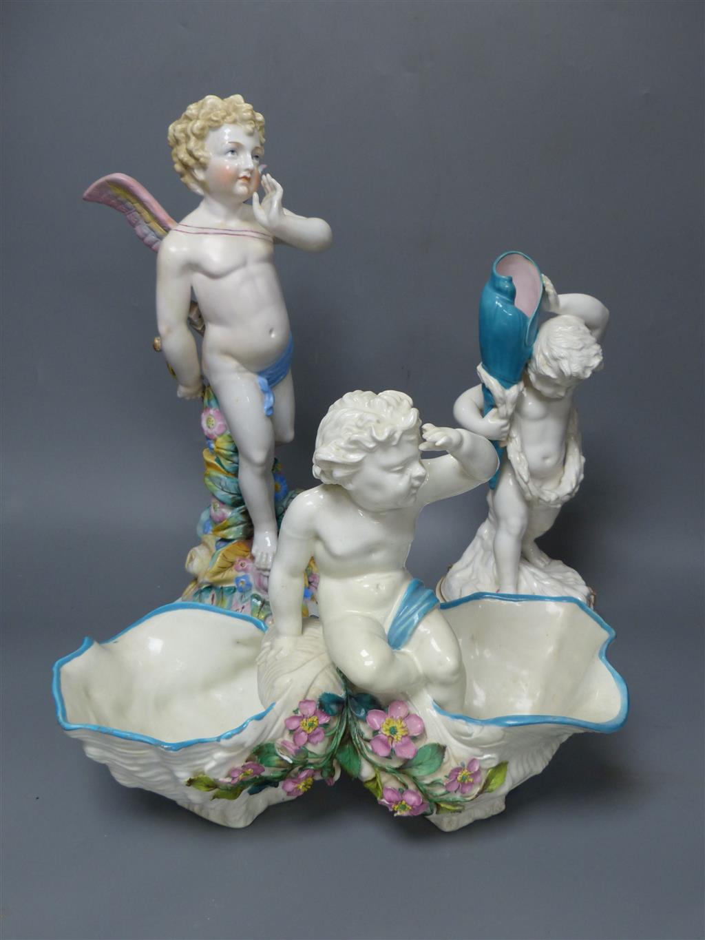 A large late 19th century French porcelain figure of Cupid, an English bone china cherub vase and a similar sweetmeat dish, tallest 3